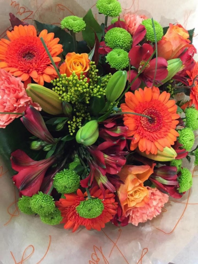 Autumn Handtied - A beautiful vibrant selection of seasonal flowers, including orange Gerbra, Scented Lily, Roses, Shamrock blooms, and zesty orange roses, beautifully gift wrapped with a funky orange theme. 

A bright scented and cheerful hand tied bouquet delivered in water by your local florist Susettes Flowers in Bury St Edmunds and surrounding villages. Same day delivery available. 

Please note that due to the seasonal availability of flowers it may be necessary to vary individual stems from those shown. Our skilled florists may substitute flowers for one similar in style, quality and value. Where our designs include a sundry item like a vase or basket it may not always be possible to include the exact item as displayed. If such an occasion arises we will make every effort to replace the item with a suitable alternative.