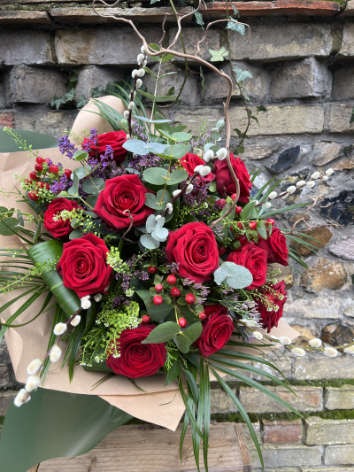 Luxury Red Dozen - Simply the best dozen red roses mixed with seasonal foliage, pussy willow, red hypericum berries finished with folded aspadistra and palm leaves, delivered handtied in water.

When only the best will do...This is the perfect romantic flower delivery on Valentine's Day or any other day just because......

Image shown is 12 red roses (standard).

Also avaiable in 18 (deuluxe) & 24 (luxury)

Please note that due to the seasonal availability of flowers it may be necessary to vary individual stems from those shown. Our skilled florists may substitute flowers for one similar in style, quality and value. Where our designs include a sundry item like a vase or basket it may not always be possible to include the exact item as displayed. If such an occasion arises we will make every effort to replace the item with a suitable alternative.