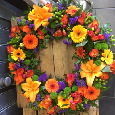 Vibrant Autumnal Wreath - Autumnal Orange Lily & Rose Wreath
A beautiful orange Lily & Rose wreath. Roses, Chrysanthemums, Lilys and Orange Germini sit perfectly alongside variegated lime hypericum berries, red freesia, Cocculus, Salal and green button chrysanthmums.

Hand delivered by your local florist in Bury St Edmunds, Susettes Flowers.

Image shown is Luxury 16".

Also available in Standard 12" & Deluxe 14" Sizes.

 

Please note that due to the seasonal availability of flowers it may be necessary to vary individual stems from those shown. Our skilled florists may substitute flowers for one similar in style, quality and value. Where our designs include a sundry item like a vase or basket it may not always be possible to include the exact item as displayed. If such an occasion arises we will make every effort to replace the item with a suitable alternative.