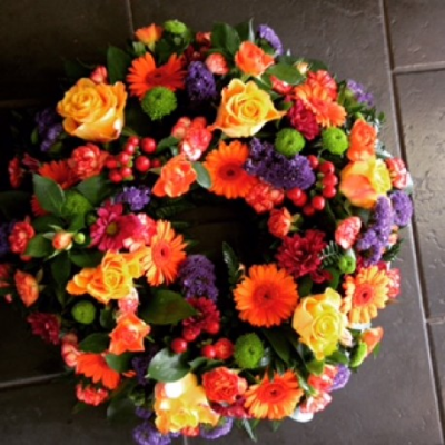 Vibrant loose wreath - Vibrant Wreath
A beautiful orange Lily & Rose wreath. Roses, Chrysanthemums, Lilys and Orange Germini sit perfectly alongside variegated lime hypericum berries, red freesia, Cocculus, Salal and green button chrysanthmums.

Hand delivered by your local florist in Bury St Edmunds, Susettes Flowers.

Image shown is Luxury 16".

Also available in Standard 12" & Deluxe 14" Sizes.

 

Please note that due to the seasonal availability of flowers it may be necessary to vary individual stems from those shown. Our skilled florists may substitute flowers for one similar in style, quality and value. Where our designs include a sundry item like a vase or basket it may not always be possible to include the exact item as displayed. If such an occasion arises we will make every effort to replace the item with a suitable alternative.