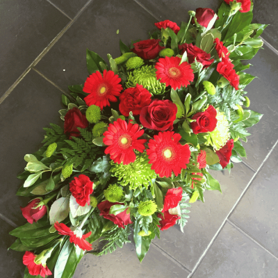 Red Double Ended Spray - A classic red double ended spray. Featuring red Roses, Gerbera, Carnations and Cordyline with a flourish of Red Roses.

Standard 2ft, Deluxe 2.5 ft, Luxury 3ft

Please note this item is only suitable for delivery to a funeral. Please make a selection from an alternative range, if you would like to express your sympathy to the bereaved. Product photography is indicative of the highest price point. Please note that seasonal availability of individual stems may vary from those in the picture. Our professional florist may substitute flowers for a suitable alternative, similar in style, colour, quality and value. Where flower designs include a sundry item such as a vase or basket it may not always be possible for our florists to include the exact item pictured. Every effort will be taken to ensure that the item is substituted for a similar design.Price above includes delivery charge but excludes relay fee.