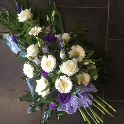 Purple & White Single Ended Spray - A gorgeous white and purple single ended spray. White Longiflorum Lilies, Germini and Carnations are interspersed with purple traclium and Lilac Freesia. Luscious green foliage completes the design beautifully. purple and white single ended spray.