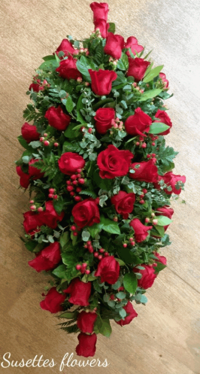 Red Rose Casket Spray - A luxurious red Rose casket spray. An abundance of gorgeous red Roses, entertwined with lush red hypericum berrys, interspersed with Asparagus Fern, trailing Ivy and Palm leaves.

Hand delivered by your local florist in Bury St Edmunds

Image shown is Standard 3ft

Also avaiable in Medium 4ft & Large 5ft