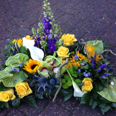 Contemporary Pillow - A gorgeous blue and yellow Pillow. Sunflowers and Roses, green Anthriums, Chrysanthemums, Orchids, Calla's Larkspur and Hypericum with a touch of Willow and blue forget me nots,  on a bed of foliage.

Image shown is Large