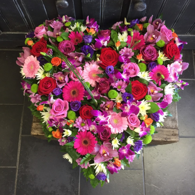 Loose Vibrant Heart - A clustered pink loose heart. Roses, Gerbra, Orchids, Lisianthus, Carnations and Eustomia make this design and vibrant and welcoming tribute. 

Image Shown is Large 17"

Available in Standard 12" and Medium 15"