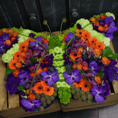 Butterfly Tribute - A pretty vibrant butterfly tribute created with orange Gerbera and lime carnations, orange roses and stunning Vanda Orchids, with a selection of seasonal flowers. 

Also available in colours of cholice, please call us on 01284 753777 to discuss your requirements.