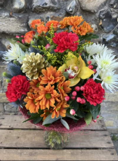 Deck the halls - A vibrant floral display delivered in a vase, with a bright array of long lasting seasonal blooms in red, golds and white.